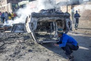 Des gens examinent la carcasse d'une voiture incendiée... (PHOTO MUJAHID SAFODIEN, AFP) - image 4.0