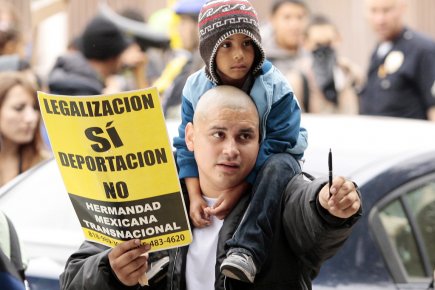Un immigrant hispanique manifeste, un enfant sur les... (Photo: Jason Redmond, Reuters)