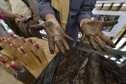 Pollution: Chevron sommée de payer 19 milliards Des activistes montrent des échantillons de terre mêlés... (Photo: AFP)