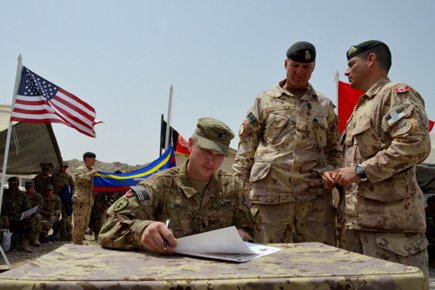 Le lieutenant-colonel Michel-Henri Saint-Louis (à droite), qui dirige le 1er Bataillon Royal 22e Régiment de Valcartier depuis 2009, et le brigadier-général Dean Milner, commandant des troupes canadiennes en Afghanistan, regardent le lieutenant-colonel américain Steve Miller, qui signe les documents de transfert d'autorité. Le lieutenant-colonel Michel-Henri Saint-Louis (à droite), qui dirige... (Photo: PC)