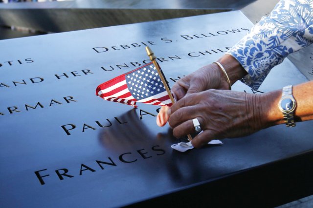 Une femme place un drapeau américain miniature sur... (PHOTO MIKE SEGAR, REUTERS)