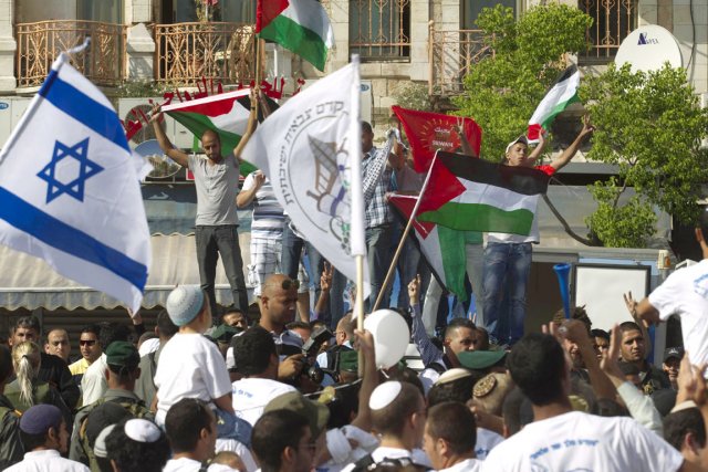 Des militants palestiniens manifestent en brandissant leur drapeau... (PHOTO MENAHEM KAHANA, ARCHIVES AFP)