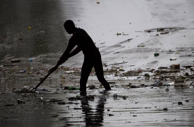 Un Dominicain nettoie la rue après le passage... (Photo: AFP)