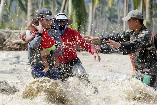 Des secouristes évacuent un bambin rescapé des inondations... (PHOTO ERIK DE CASTRO, REUTERS)