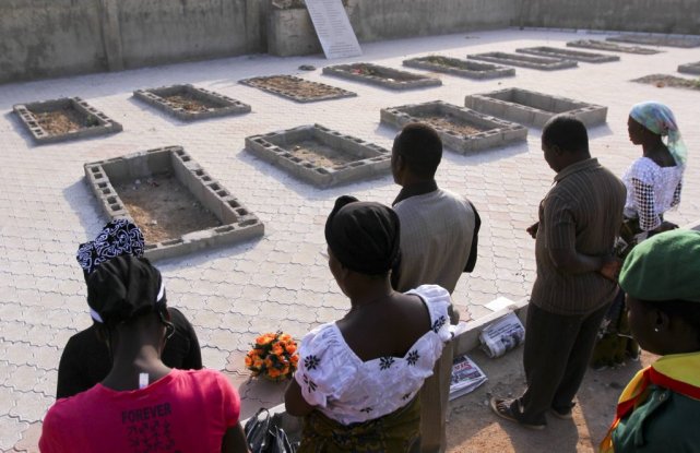 Des chrétiens prient sur les tombes de victimes... (PHOTO AFOLABI SOTUNDE, REUTERS)