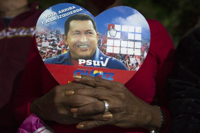 Une partisane du président Chavez tient une photo... (PHOTO Carlos Garcia Rawlins, REUTERS)