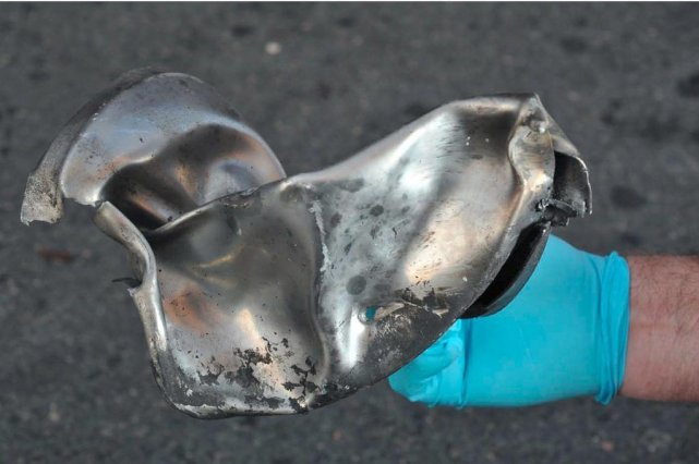 Un enquêteur montre un morceau de métal retrouvé... (PHOTO  REUTERS)