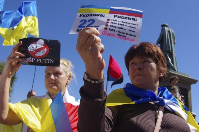 Sanctions: l'UE lance un ultimatum à la Russie Des femmes tiennent des brochures où il est... (PHOTO ALEXEY KRAVTSOV, AFP)