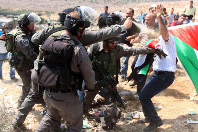 Un policier anti-émeute israélien utilise du poivre de... (PHOTO MUSA AL SHAER, AFP)