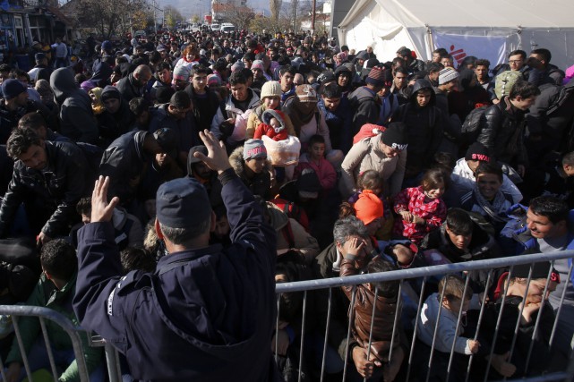 La bataille des pétitions sur l'accueil de réfugiés enflamme le web Un officier de police incite des migrants à... (AP, Darko Vojinovic)