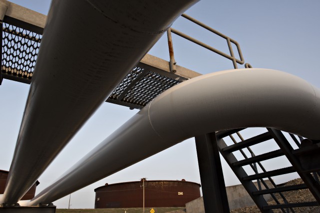 OIL STORAGE Pipelines run toward oil storage tanks stand at... (La Presse Bloomberg)