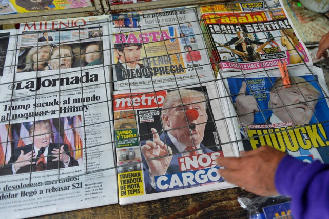 Un vendeur de journaux observe les unes des... (photo PEDRO PARDO, AFP)