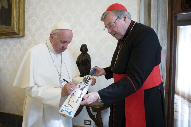 Le numéro 3 du Vatican inculpé pour sévices sexuels sur enfants Le cardinal George Pell offrant une batte de cricket... (ARCHIVES AP)