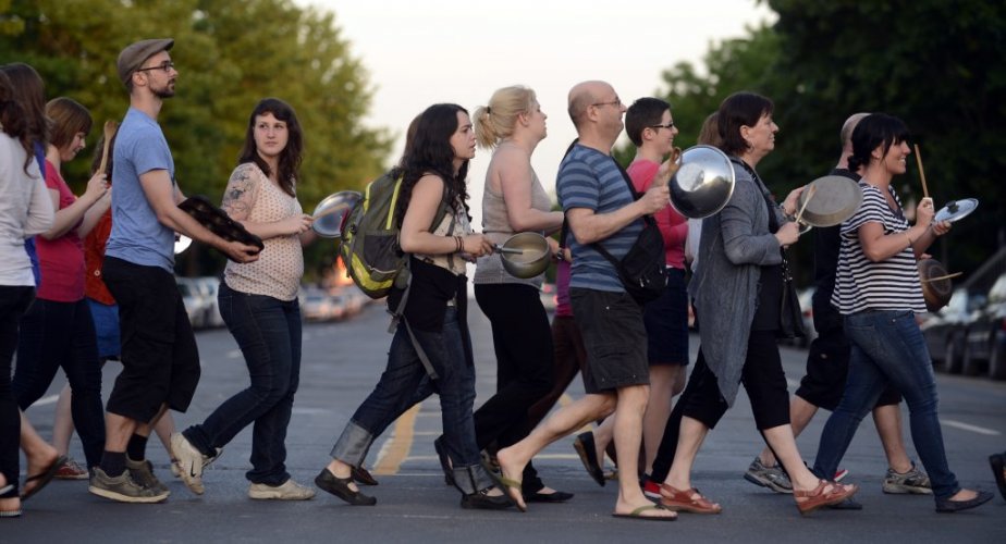Photo : une dizaine de personnes traversent ensemble la rue, en fil, mais avec casseroles et instruments musicaux. C'était une manif-casseroles en 2012 à Montréal. Des gens entre 30 et 50 ans.