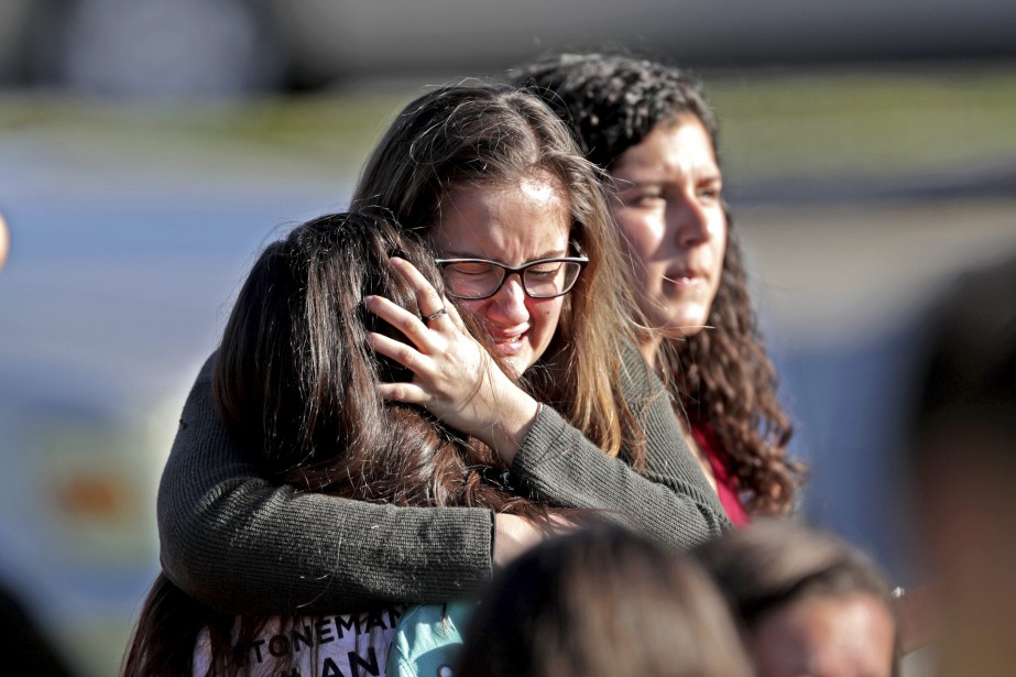 Des élèves s'enlacent après avoir évacué l'école.... (Photo John McCall, South Florida Sun-Sentinel via AP)