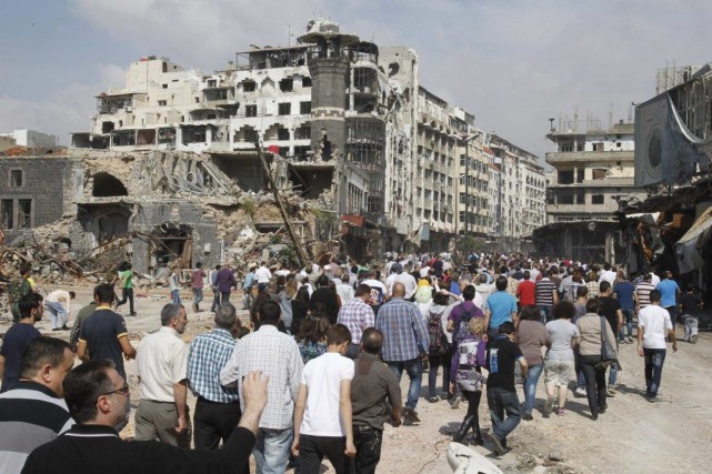 Des résidants de Homs retrouvent leur ville, dévastée Des centaines d'hommes, de femmes et d'enfants ont... (KHALED AL-HARIRI, Reuters)