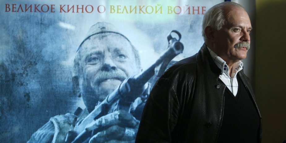 Le réalisateur Nikita Mikhalkov pose devant l'affiche de...