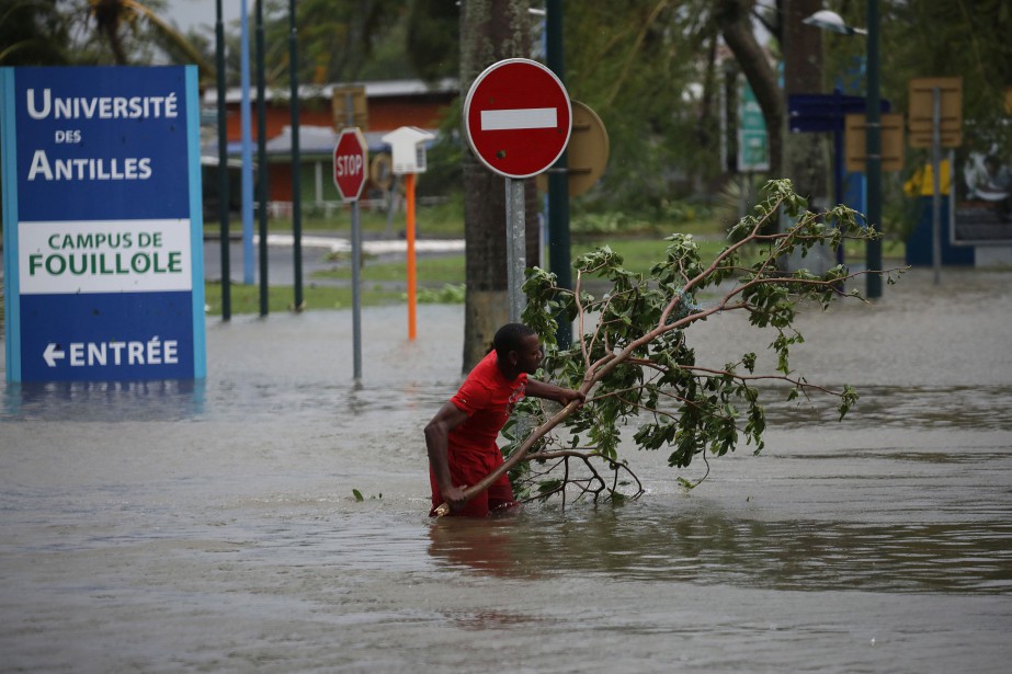 Un homme retire une branche d'une rue inondée... (REUTERS)